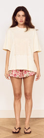 Model wearing Crochet Detail Oversized T Shirt with crochet applique design and scalloped edging, paired with floral shorts.