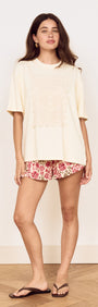 Model wearing Vintage Floral Print Mini Shorts with a cream tonal top, showcasing a relaxed summer outfit.