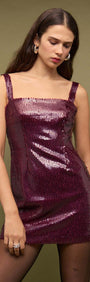 Model wearing a Purple Sequin Mini Dress with a square neckline and wide straps, showcasing burgundy sequins.