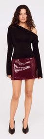 Model wearing a black top and the Purple Sequin Mini Skirt, showcasing its burgundy sequins and stylish design.