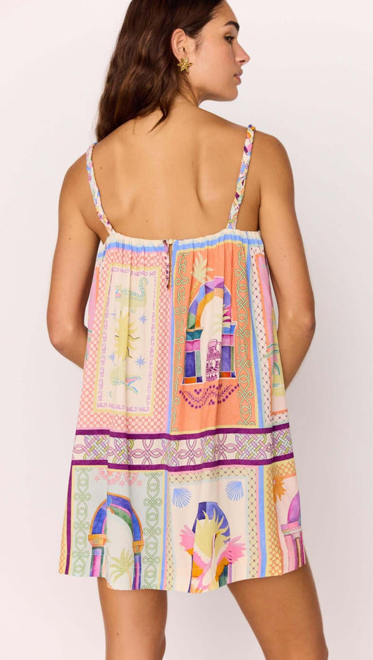 Back view of a model wearing a multicolour print Babydoll Mini Dress, showcasing its vibrant patterns and straps.