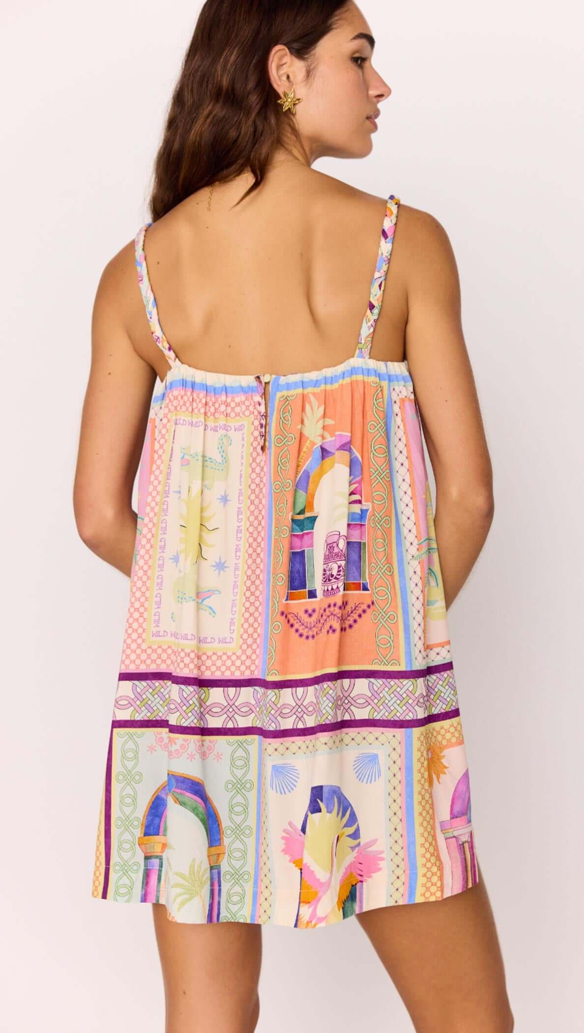 Back view of a model wearing a multicolour print Babydoll Mini Dress, showcasing its vibrant patterns and straps.