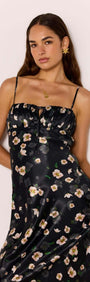 Model wearing a Black Floral Bias Midi Dress with a ruched bust and adjustable straps, showcasing silk floral satin fabric.