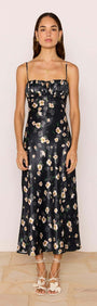 Model wearing a Black Floral Bias Midi Dress with adjustable straps and ruched bust showcasing a floral satin fabric.