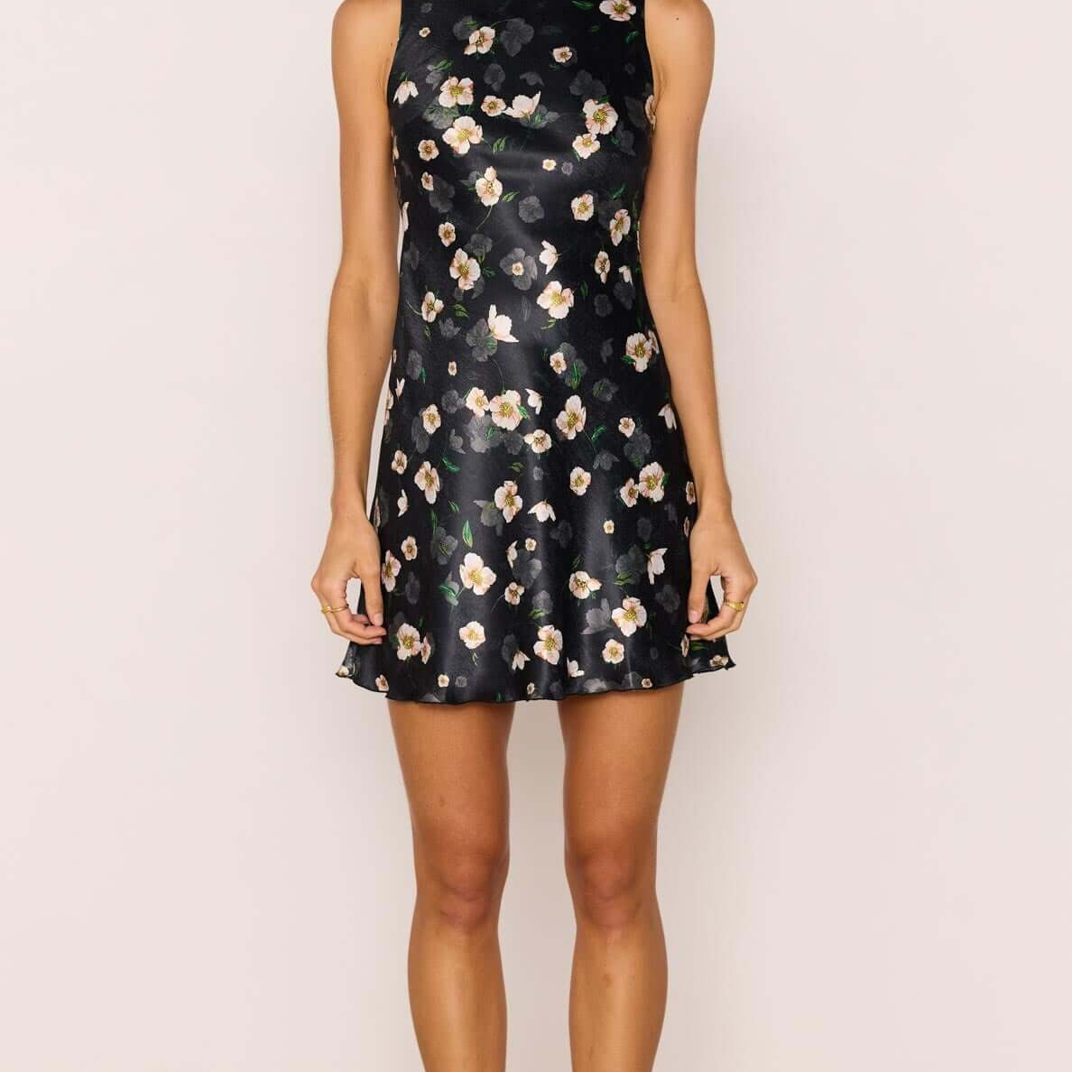Model wearing a Black Floral Bias Mini Dress featuring a high neckline and open back design.