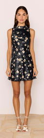 Model wearing a Black Floral Bias Mini Dress featuring a high neckline and open back design.