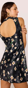 Woman wearing Black Floral Bias Mini Dress showcasing open back design and floral satin fabric.