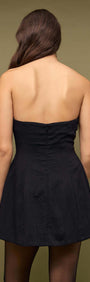 Back view of a Black Strapless Peplum Mini Dress highlighting its sleek silhouette.