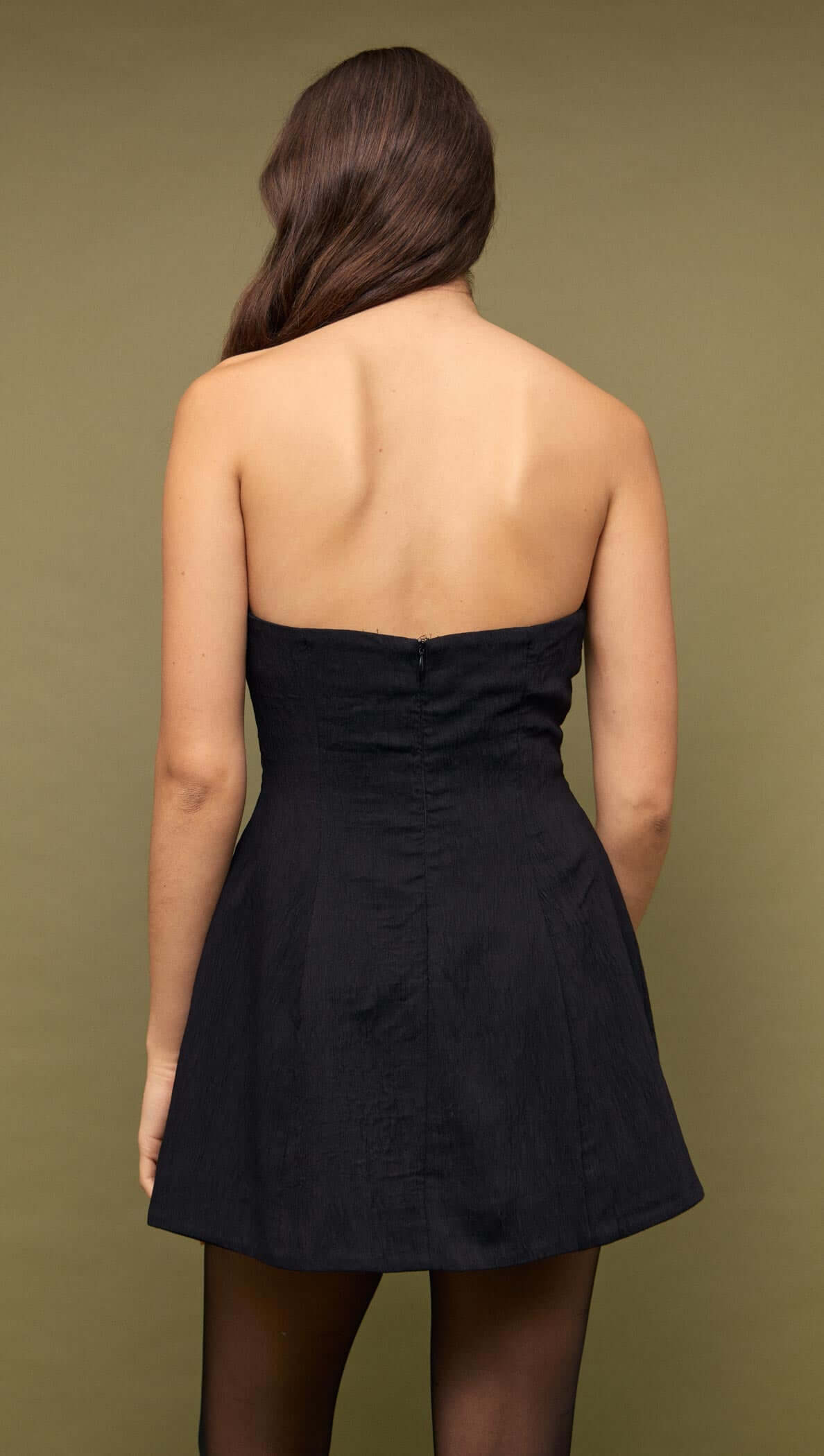 Back view of a Black Strapless Peplum Mini Dress highlighting its sleek silhouette.