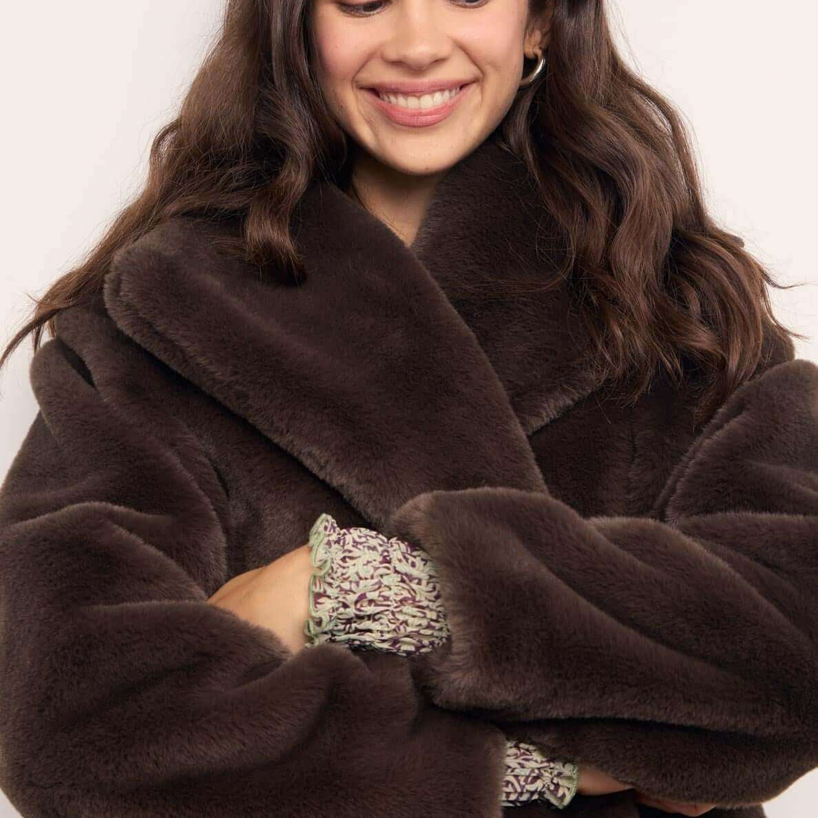 Brown Faux Fur Coat worn by a smiling woman with wavy hair, showcasing its plush texture and oversized collar.