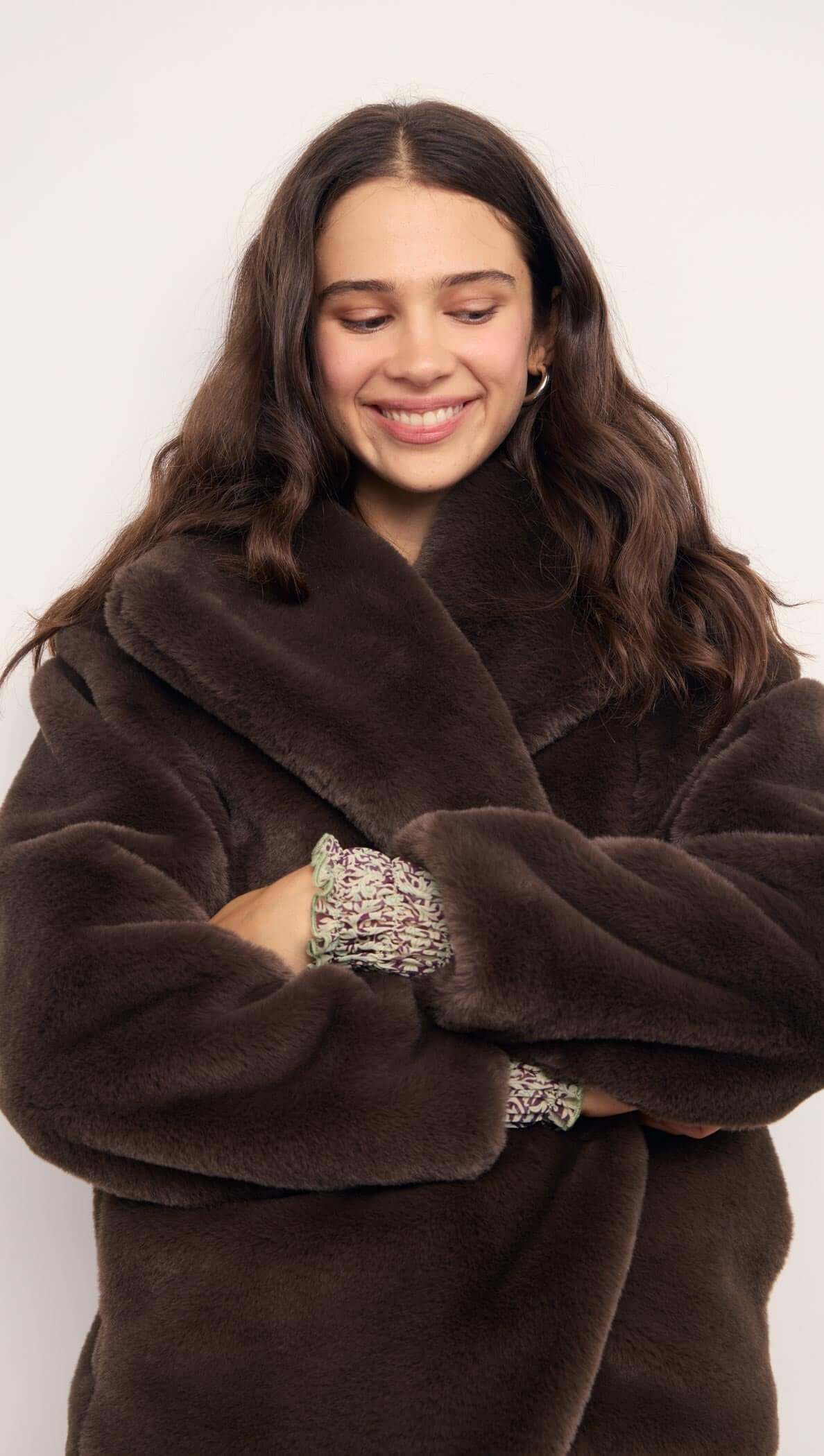Brown Faux Fur Coat worn by a smiling woman with wavy hair, showcasing its plush texture and oversized collar.