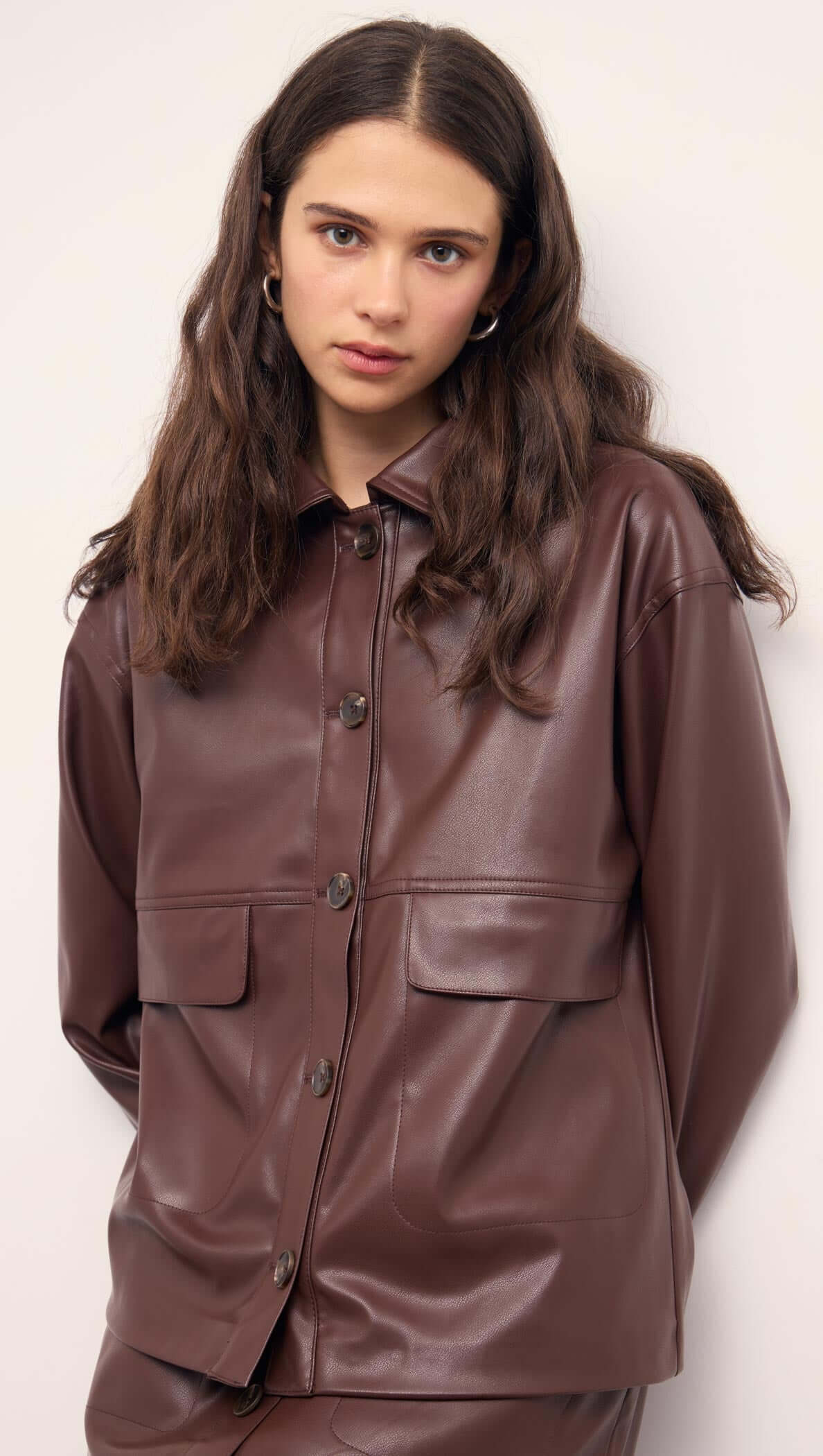 Brown Faux Leather Jacket worn by a model, featuring button-front closure and statement pockets, showcasing a relaxed silhouette.