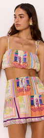 Model wearing a multicolour print bubble crop top with tie straps and matching skirt, perfect for summer style.