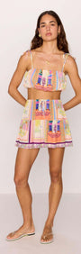 Model wearing a multicolour print bubble crop top with tie straps and matching skirt, ideal for summer style.