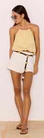 Butter Yellow Halter-Neck Low Back Bubble Top styled with white shorts and sunglasses, perfect for summer fashion.