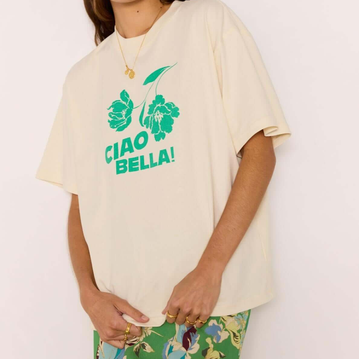 Ciao Bella Relaxed Cotton Oversized Tee featuring bold green print on soft cotton, styled with a floral skirt.