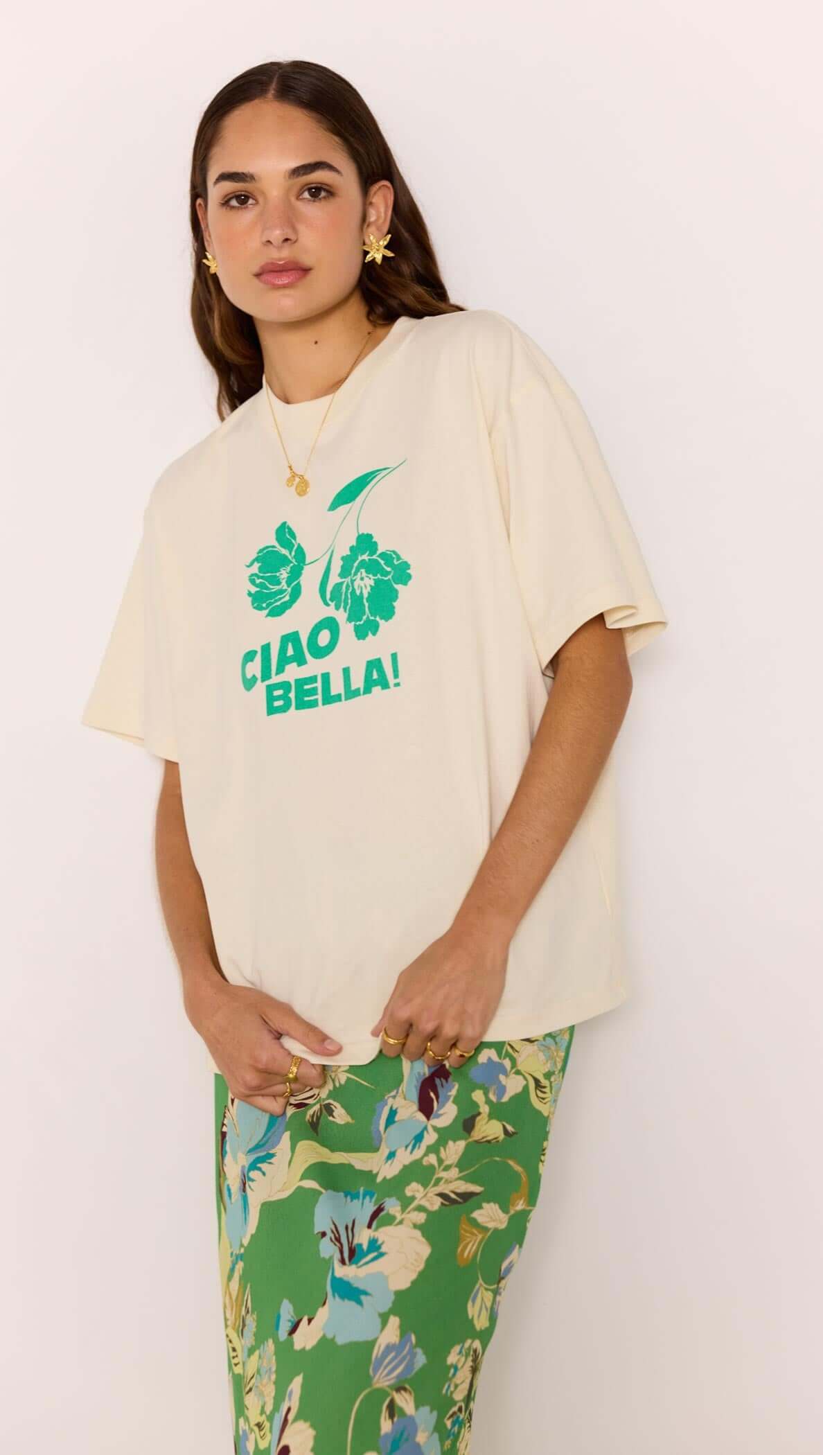 Ciao Bella Relaxed Cotton Oversized Tee featuring bold green print on soft cotton, styled with a floral skirt.