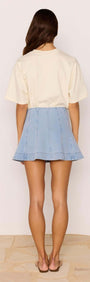 Back view of a model wearing the Denim Flared Mini Skirt styled with a casual top.