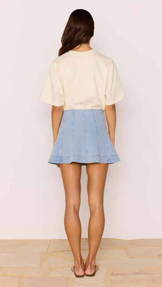 Back view of a model wearing the Denim Flared Mini Skirt styled with a casual top.