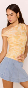 Model wearing a soft yellow one-shoulder top with a Denim Flared Mini Skirt, showcasing a playful and stylish outfit.