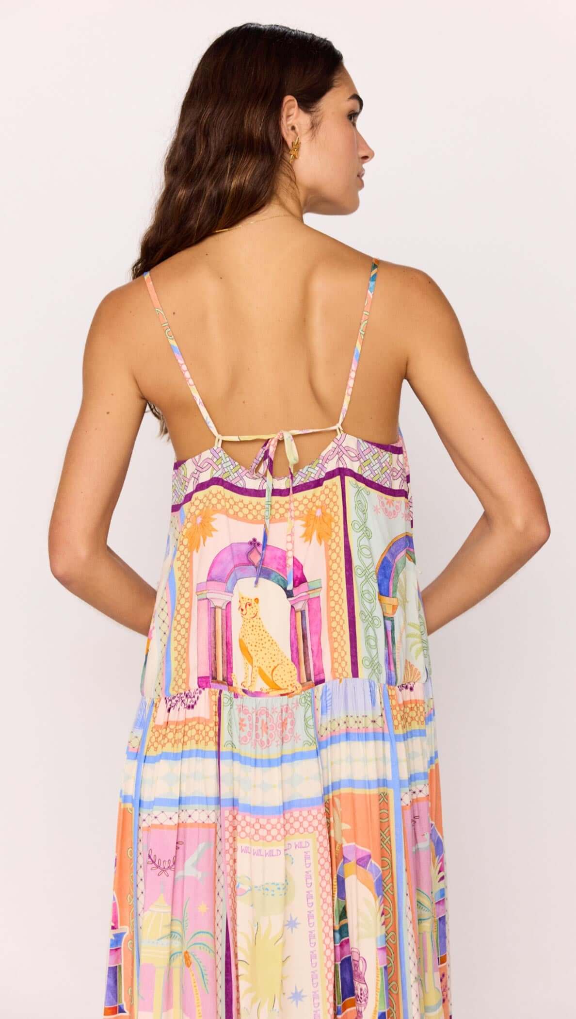 Back view of a model wearing a multicolour print dropped-waist strappy midi dress with a tie detail.