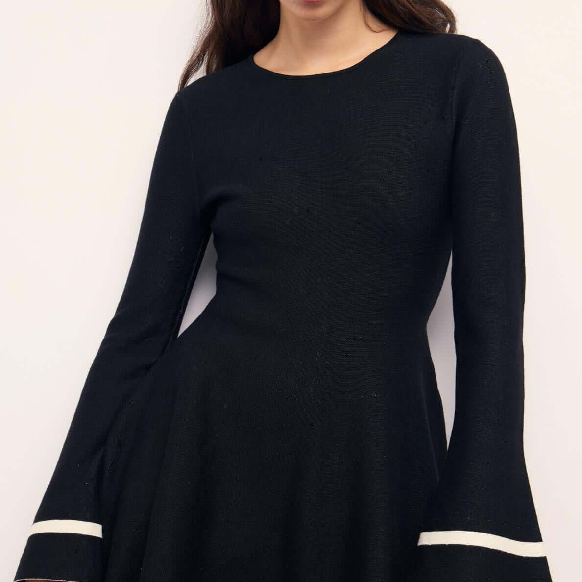 Black Peplum Knit Mini Dress With Contract Trim featuring flared sleeves and chic contrast trim.
