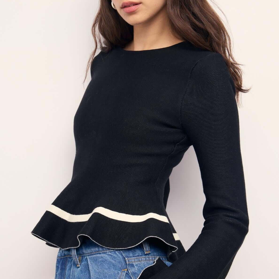 Black Peplum Knit Top With Contrast Trim, featuring long sleeves and a playful peplum hem for a chic look.