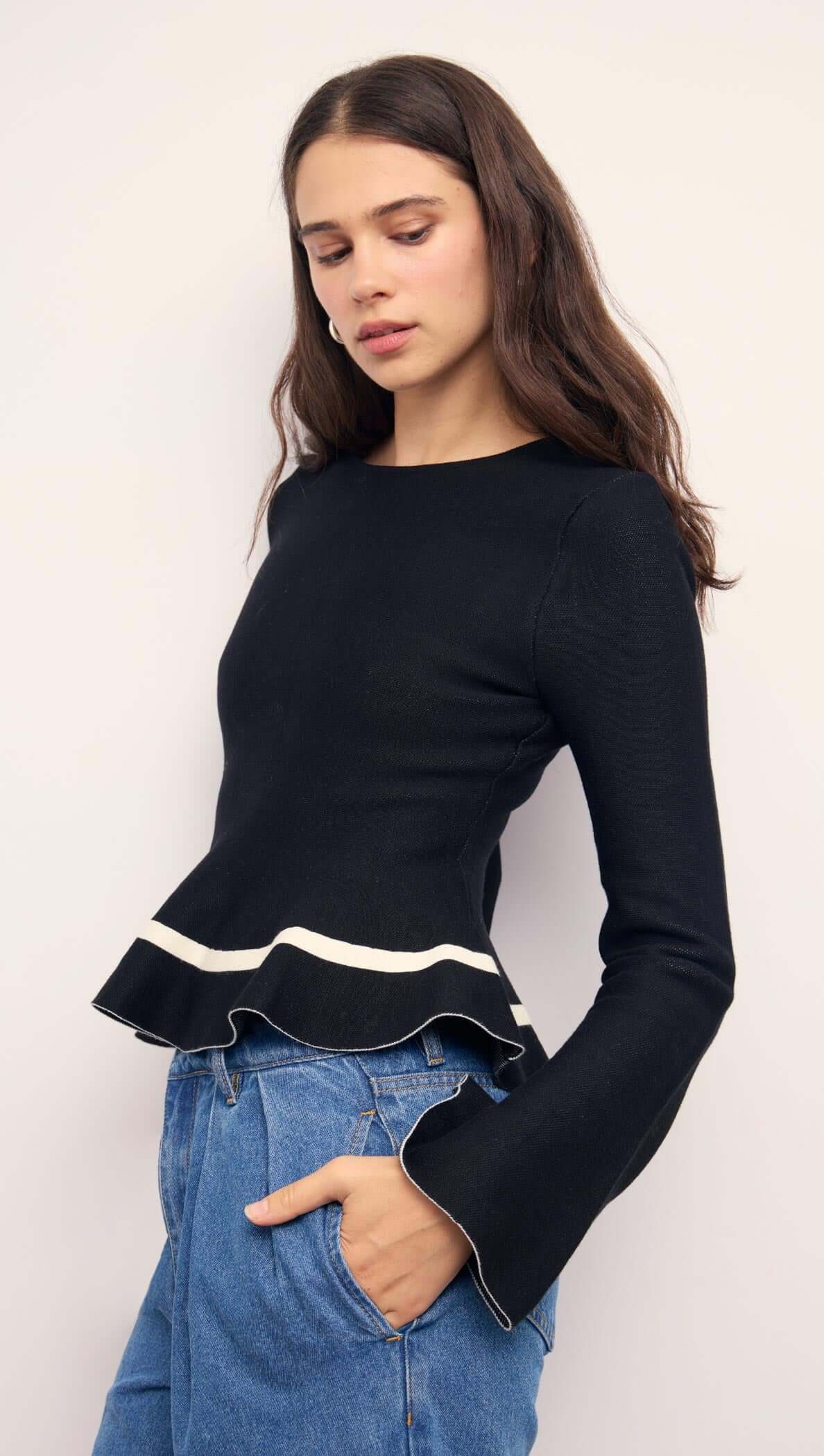 Black Peplum Knit Top With Contrast Trim, featuring long sleeves and a playful peplum hem for a chic look.
