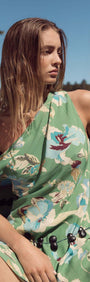 Model wearing a Green Floral Asymmetric Mini Dress in a breezy outdoor setting.