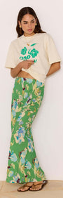 Model wearing a Green Floral Bias Midi Skirt paired with a graphic tee and sandals, showcasing a vibrant floral design.