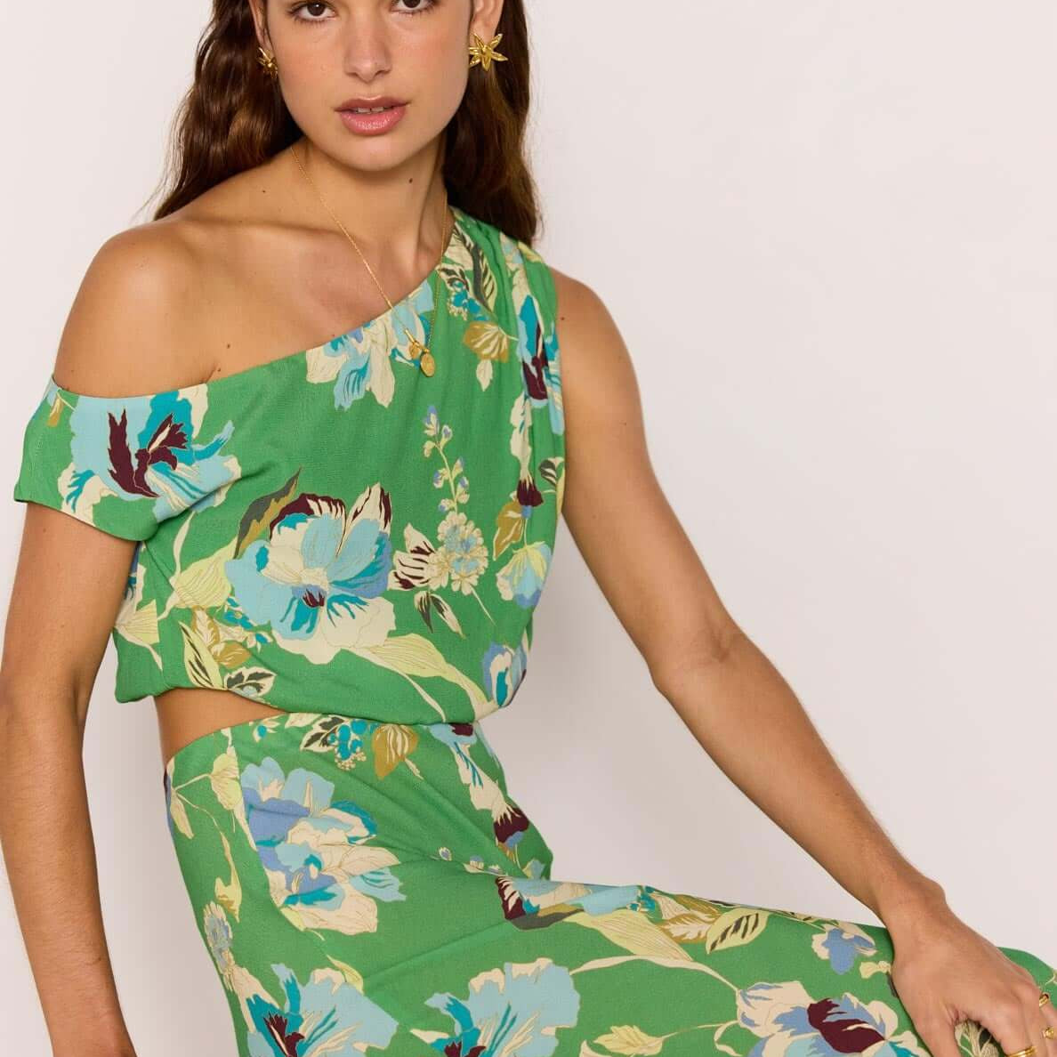 Model showcasing the Green Floral Crop Top with one-shoulder design in a vibrant floral print, perfect for summer.