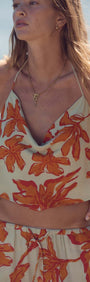 Model wearing the Green & Orange Floral Cowl Neck Scarf Top by Estelle, featuring a soft cowl neckline and sunset floral print.