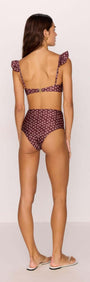 Back view of a woman wearing a burgundy floral print high-waisted bikini pant with ruffled straps.