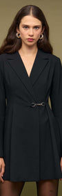 Black Blazer Mini Dress With Buckle Detail worn by a model against a neutral background, showcasing its tailored design.