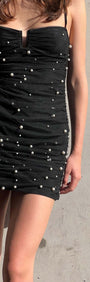 Model wearing Pearl Embellished Black Mesh Mini Dress with ruched detailing and pearl accents against a neutral background.