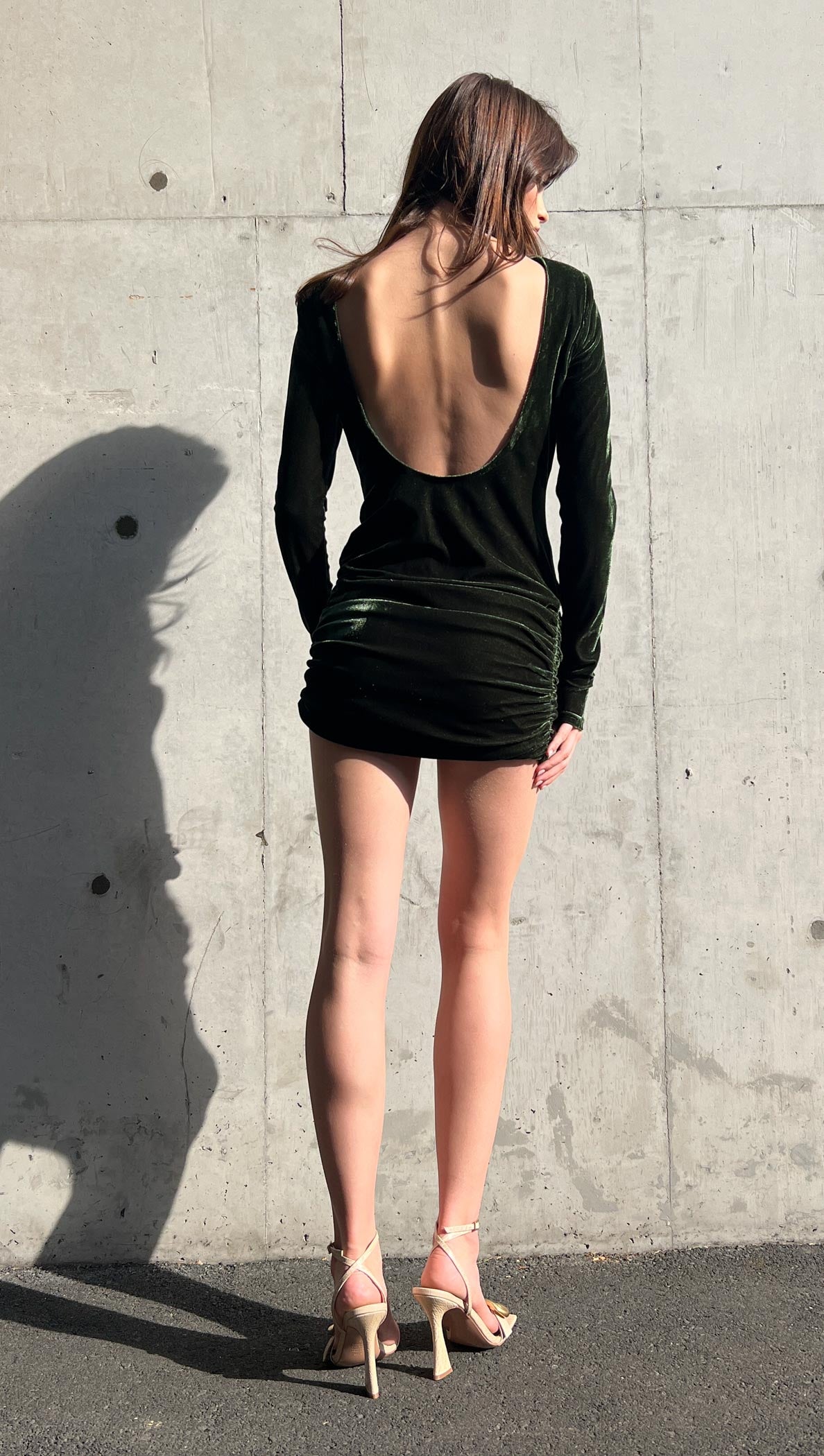 Green Velvet Open Back Mini Dress showcased from behind, featuring a daring open back and ruched skirt.