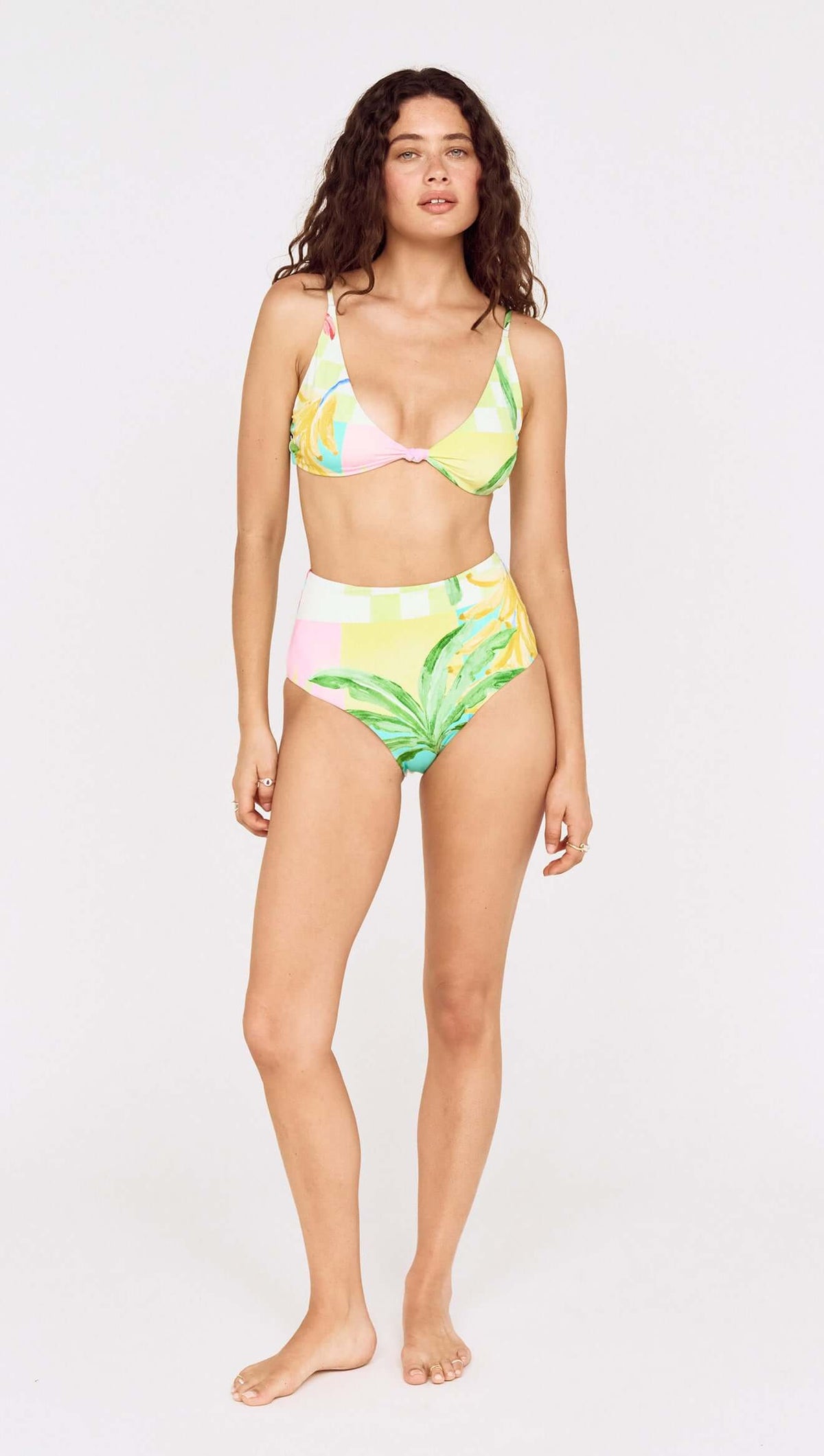 Model showcasing the Palm Print High Waisted Bikini Bottom paired with a matching top, featuring vibrant tropical colors.
