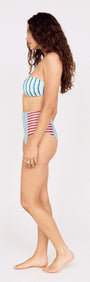 Side view of a model wearing a Contrast Stripe High Waisted Bikini Bottom with a blue and red striped design.