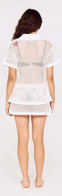Model wearing a White Crochet Mini Skirt with Embroidered Shellfish, showcasing back view with mesh shirt.