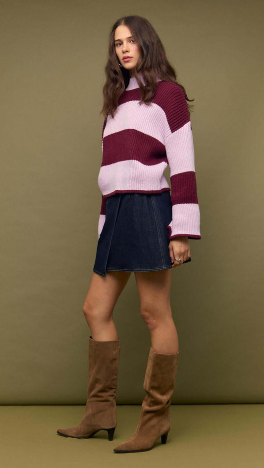 Model wearing Denim Mini Wrap Skirt With Buckle Detail and striped sweater, showcasing a stylish outfit.