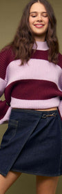 Fashionable model wearing a Denim Mini Wrap Skirt With Buckle Detail paired with a striped sweater.