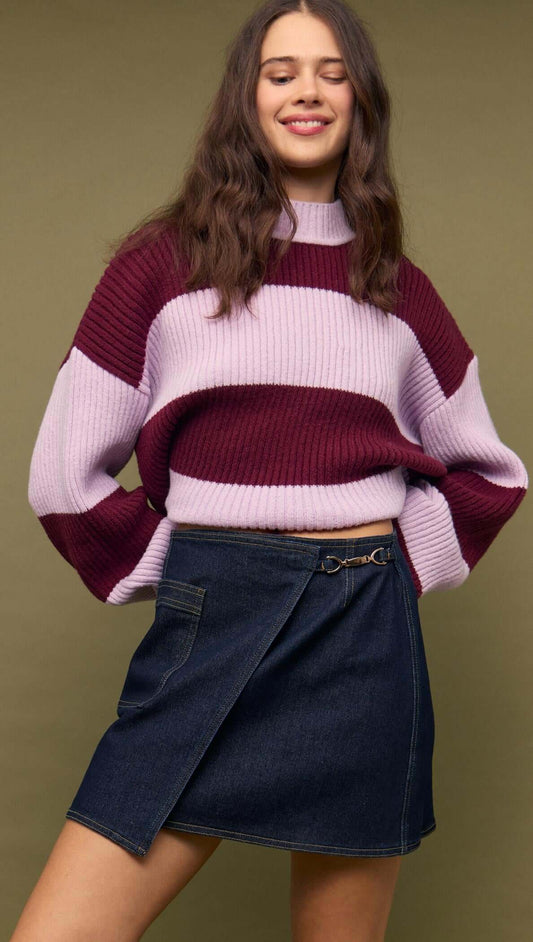 Fashionable model wearing a Denim Mini Wrap Skirt With Buckle Detail paired with a striped sweater.