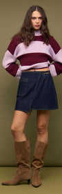Model wearing Denim Mini Wrap Skirt With Buckle Detail paired with a striped sweater and knee-high boots