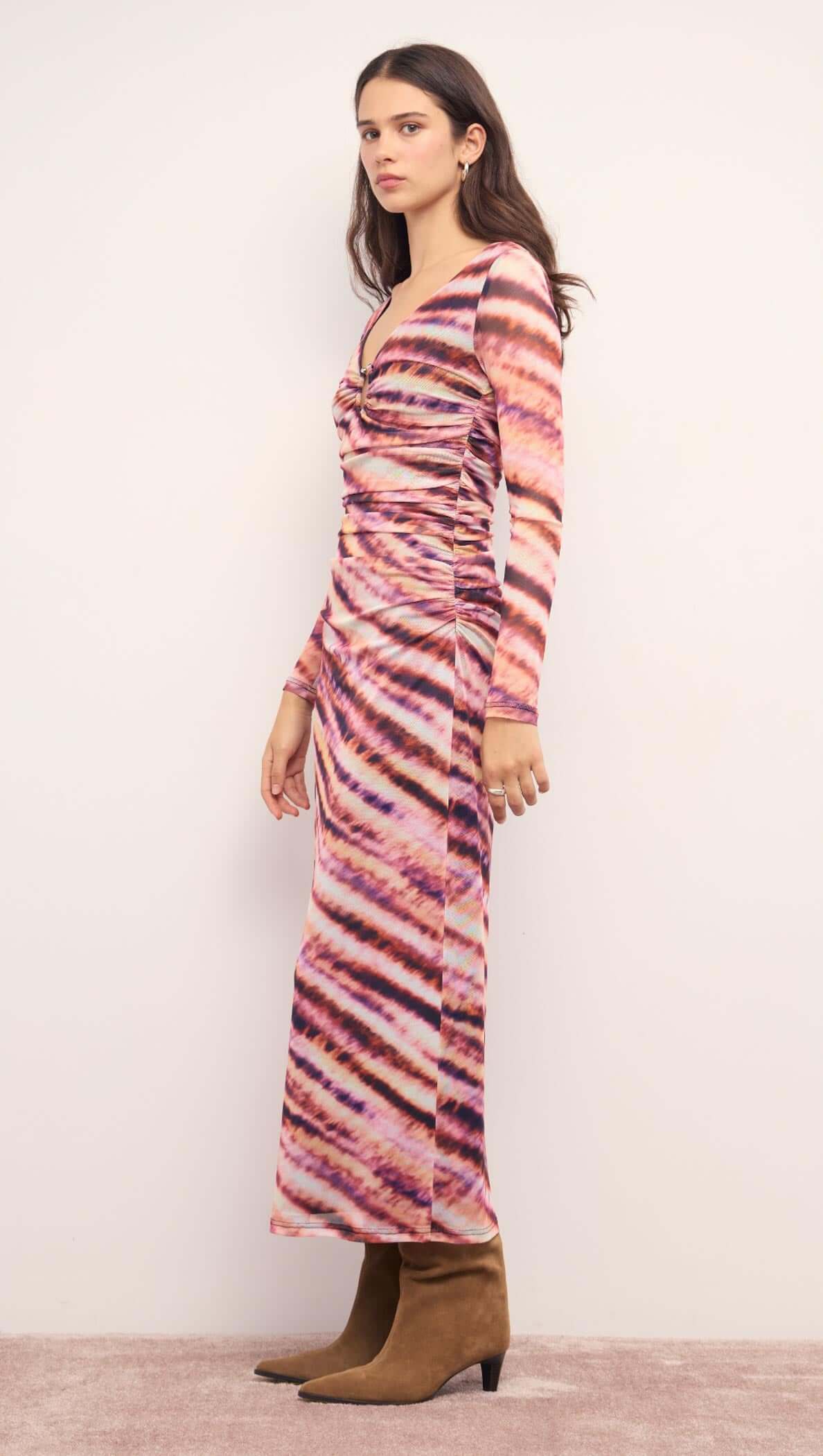 Pink &amp; Purple Striped Mesh Midi Dress shown in a side view on a model, featuring a plunging neckline and long sleeves.