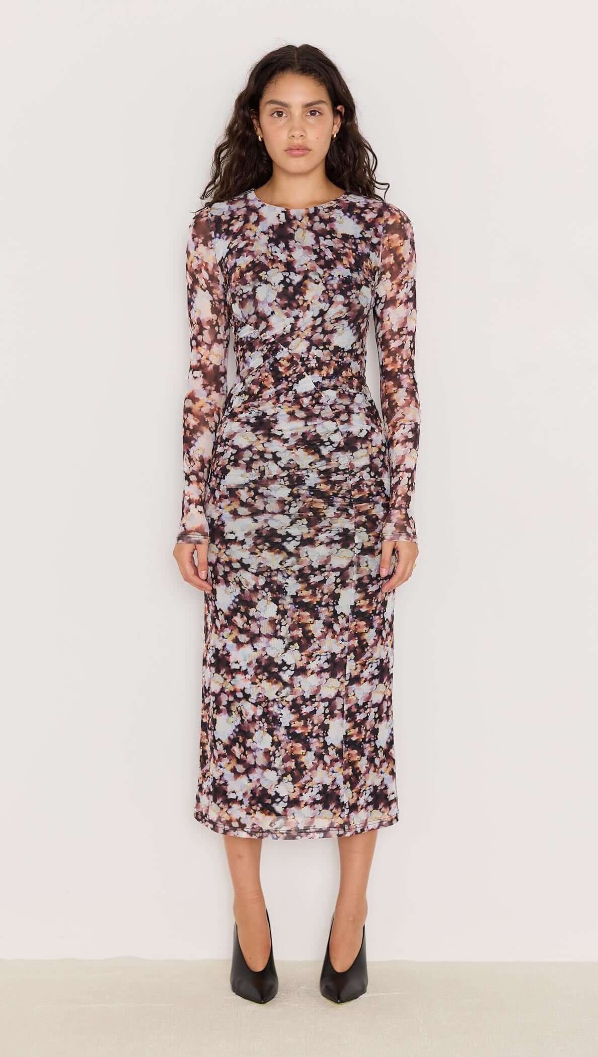 Model wearing the Audrey Mesh Midi Dress in blurred floral print, showcasing long sleeves and a flattering silhouette.