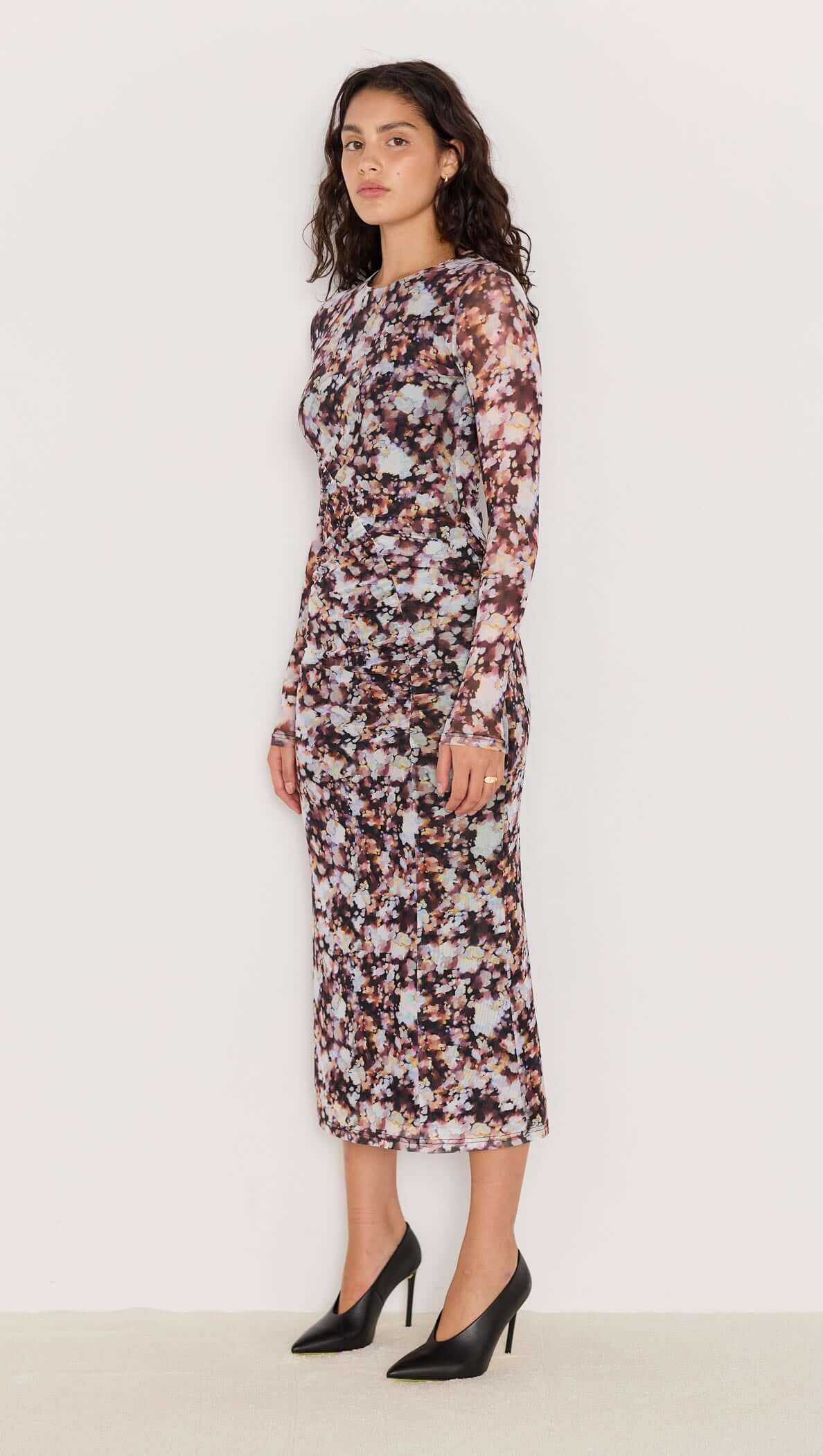 Model wearing the Audrey Mesh Midi Dress featuring a blurred floral print, long fitted sleeves, and elegant ruched detailing.