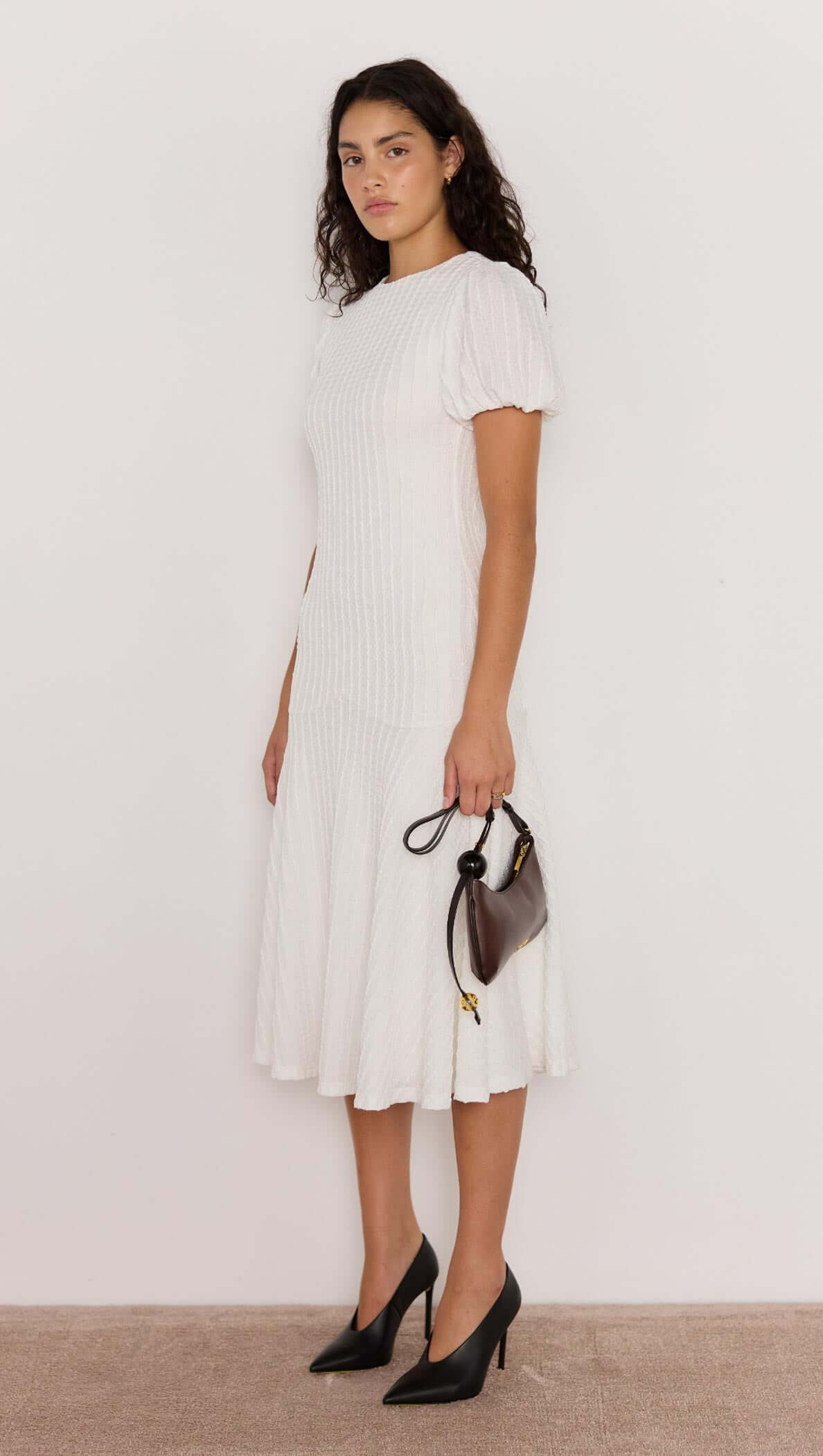 Model wearing the Anais Drop Waist Midi Dress in white, showcasing puff sleeves and a flattering drop waist silhouette.