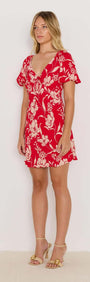 Model wearing the Poppy Mini Dress, featuring a red floral print, soft V-neckline, and floaty short sleeves.