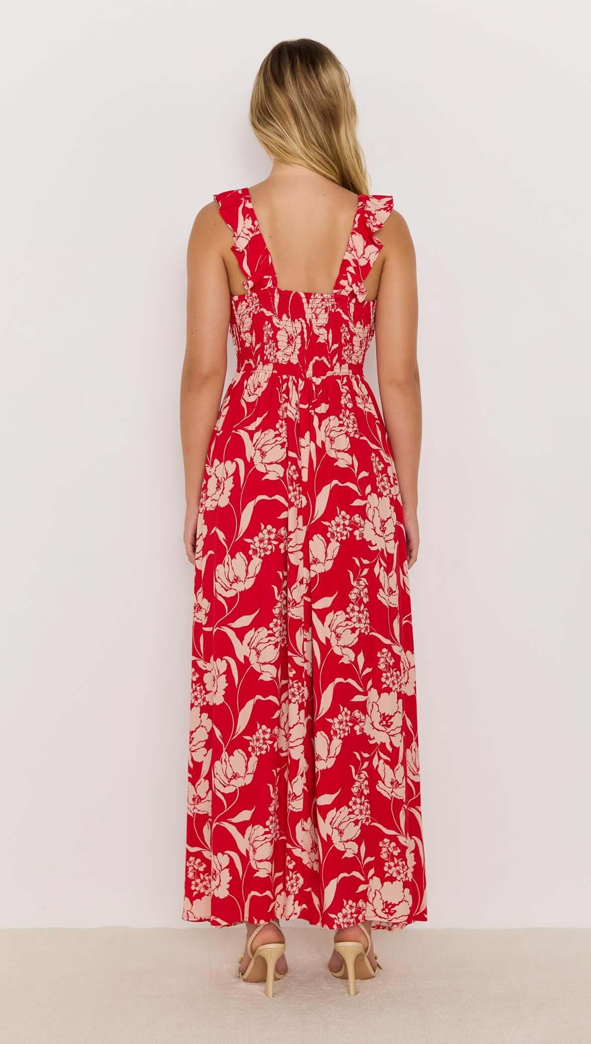 Back view of the Poppy Maxi Dress in vibrant red floral print with ruffle straps and shirred back.
