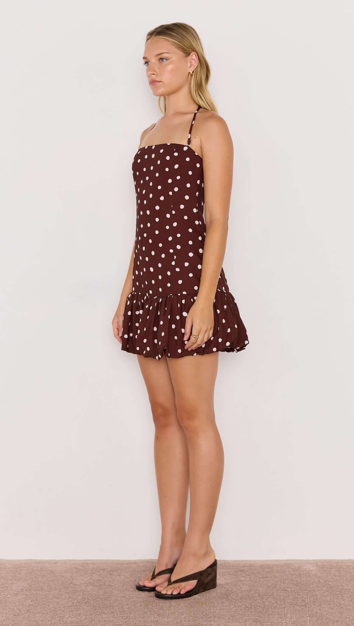 Model wearing the Cedar Spot Bubble Mini Dress, featuring chocolate brown with white polka dots and a playful bubble hem.
